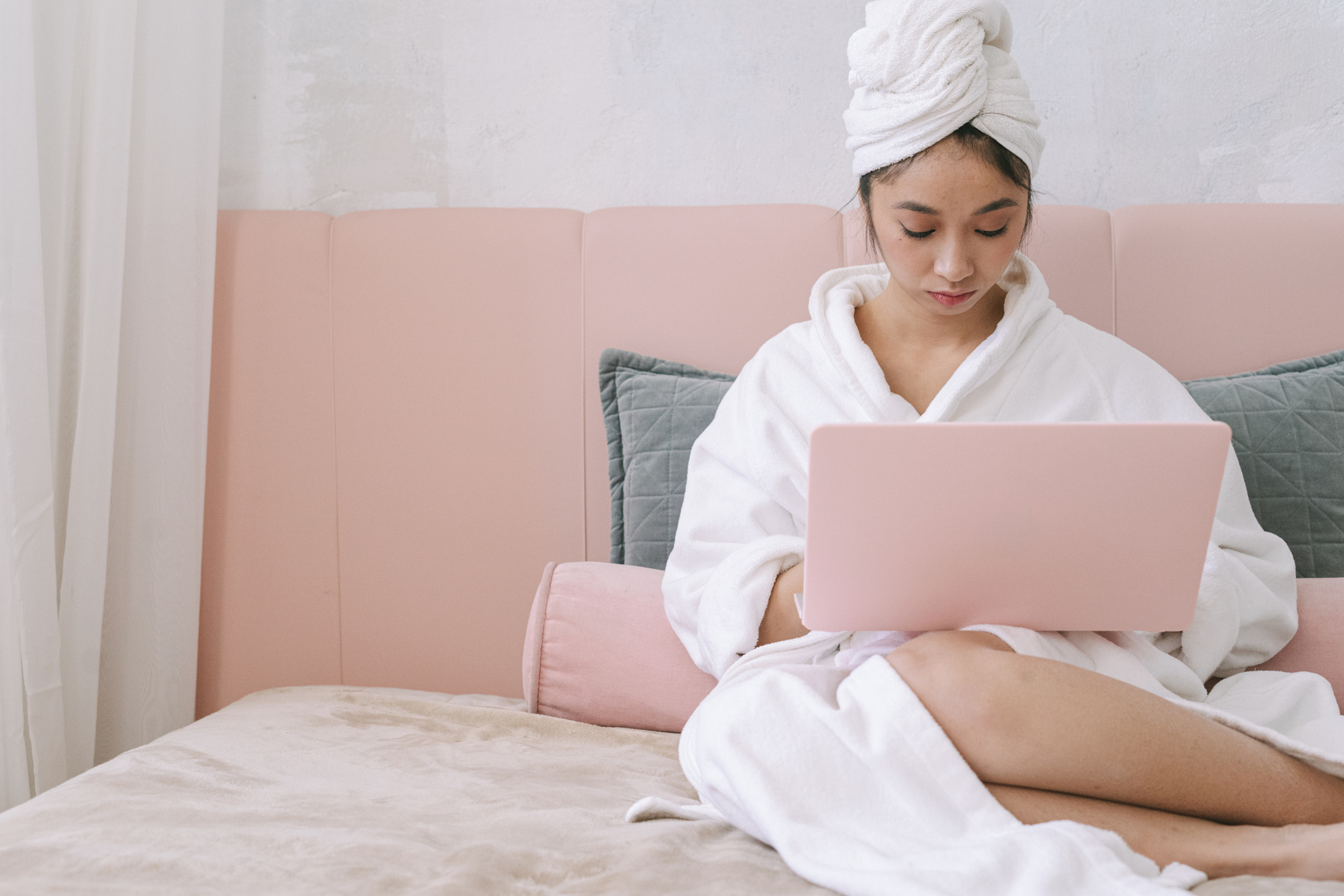 A Woman in a Bathrobe Using a Laptop